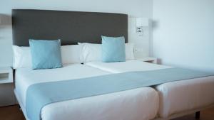 a bedroom with a large white bed with blue pillows at Hotel Bahia Sur in San Fernando +57 photos