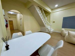 a white table and chairs in a room with a staircase at Caesar's Corner 3 Bedroom House in Ban Lak Roi