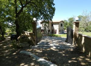 a fence with a gate in front of a house at Scappo in Umbria, Casale Rusinè in Narni