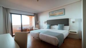 a hotel room with a large bed and a balcony at Hotel Bahia Sur in San Fernando