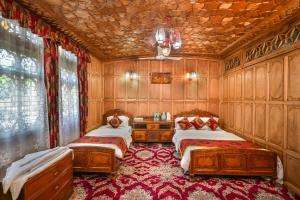 a bedroom with two beds in a room with wooden walls at Firdous Houseboats at Dal Lake in Srinagar