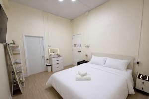 a white bedroom with a white bed and a tv at Caesar's Corner 3 Bedroom House in Ban Lak Roi