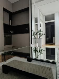a glass table in a kitchen with two potted plants at White Lounge Haustor in Podgorica