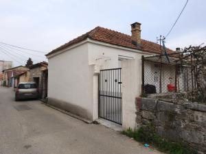 a white house with a gate on a street at Spacious City Center Apartment for 6 - Steps from Hilton & Republic Square in Podgorica
