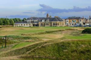 a large house on a golf course with a green at The Bunker, Golf Cottage in Prestwick