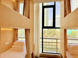 a bedroom with two beds and a large window at F18 Hub Youth Hostel in Chengdu +26 photos