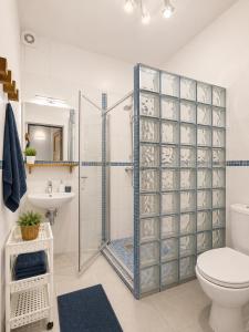a bathroom with a shower with a toilet and a sink at DOMKI NA FALI by Baltic Club in Sarbinowo +15 photos