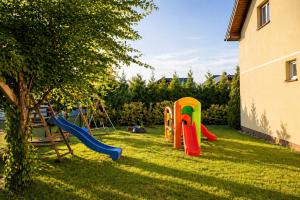 a playground in a yard next to a building at DOMKI NA FALI by Baltic Club in Sarbinowo