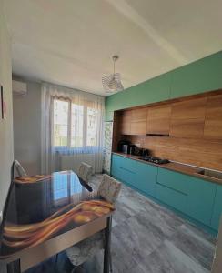 a kitchen with a glass table and blue cabinets at дом отдыха in Itʼkhvisi