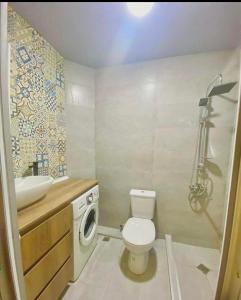 a bathroom with a toilet sink and a washing machine at дом отдыха in Itʼkhvisi