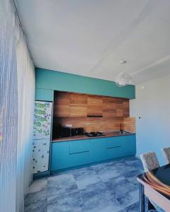 a kitchen with blue cabinets and a blue wall at дом отдыха in Itʼkhvisi