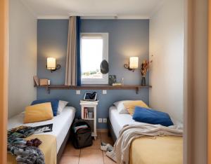 two beds in a small room with a window at Résidence Pierre & Vacances Premium Les Calanques des Issambres in Les Issambres +53 photos