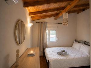 a bedroom with a bed and a table with a mirror at Wooden Loft 3min Walk to Beach in Alexandroupoli