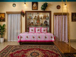 a bedroom with a pink bed and a rug at The Timeless Mysuru bungalow in Mysore