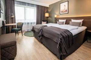 ein Hotelzimmer mit einem großen Bett und einem Stuhl in der Unterkunft Scandic Kolding in Kolding + 40 Fotos