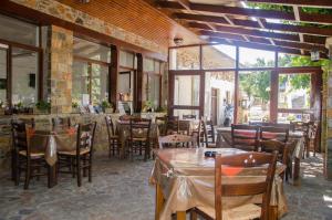 a restaurant with tables and chairs and windows at Platanos Rooms in Anopoli Sfakion