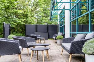 eine Gruppe von Stühlen und Tischen auf einer Terrasse in der Unterkunft Scandic Kolding in Kolding