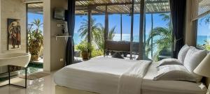 a bedroom with a bed and a view of the ocean at Villa Jacuzzi Seaview Villa in Chaweng Noi Beach