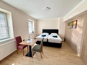 a bedroom with a bed and a table and chairs at kERVANHOF an der Donau in Kleinpöchlarn