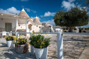 a white fence with flowers in white vases at Casa Relax Isabelle in Alberobello +50 photos