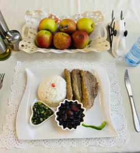 a plate of food with meat and fruit on a table at Acomodações e Serviços TR in Maputo