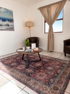 a living room with a table and a couch at Paterson Place Studios in Hermanus +11 photos