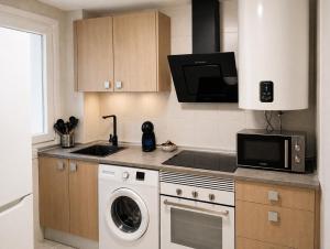 a kitchen with a washer and a microwave at Nova Suites Viveiro in Viveiro +2 photos