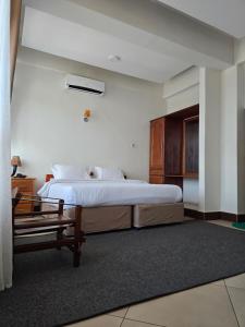 a bedroom with a large bed and a bench at Kilimanjaro Magic in Moshi