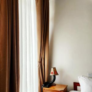 a lamp sitting on a table next to a curtain at Kilimanjaro Magic in Moshi +10 photos