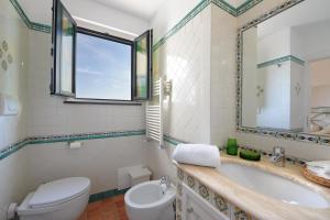 a bathroom with a tub and a toilet and a sink at Casa Alessia in Praiano +38 photos