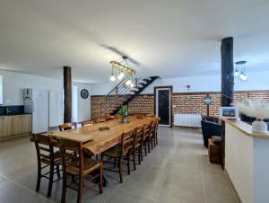 a dining room with a long wooden table and chairs at Longère à la campagne rénovée à neuf in Le Lys-Saint-Georges