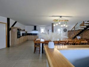 a dining room and kitchen with a table and chairs at Longère à la campagne rénovée à neuf in Le Lys-Saint-Georges +9 photos