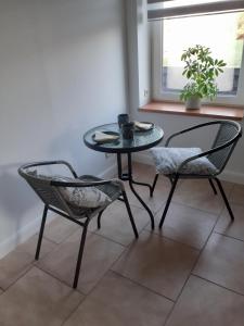 a table and two chairs in a room with a window at Erholung am Deich in Kollmar