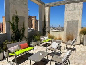 a patio with chairs and tables and large windows at Eos Hotel in Lecce