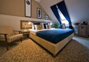 pokój hotelowy z łóżkiem i krzesłem w obiekcie Hotel Jägerhorn w Zagrzebiu