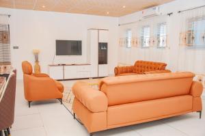 a living room with two couches and a flat screen tv at Résidence Maranatha in Cotonou