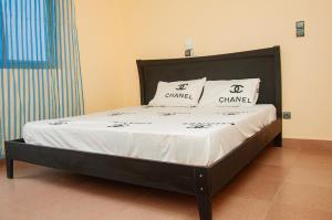 a bed in a room with two pillows on it at Résidence Maranatha in Cotonou