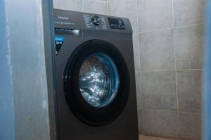 a washing machine in a corner of a room at Résidence Maranatha in Cotonou +4 photos