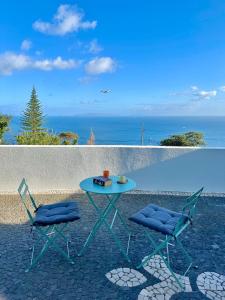 a table and two chairs sitting on a patio with the ocean at Modern Sea View Studio with Private Parking in Gaula