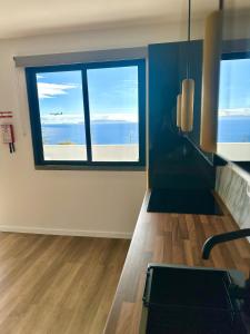 a room with a large window with a view of the ocean at Modern Sea View Studio with Private Parking in Gaula
