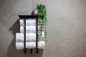 a stack of towels on a towel rack in a bathroom at Modern Sea View Studio with Private Parking in Gaula +9 photos