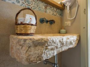 a bathroom with a stone counter with a basket on it at Trullo Soave Suite - outdoor jacuzzi in Alberobello