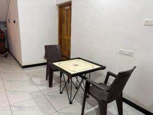 a table with two chairs and a clock on it at Green Valley Resort in Thāl
