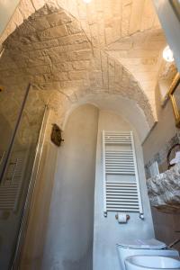 a bathroom with a sink and a toilet and a ceiling at Trullo Soave Suite - outdoor jacuzzi in Alberobello +11 photos