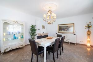 a dining room with a white table and black chairs at Villa Brisa do Mar by Algarve Holidays in Galé