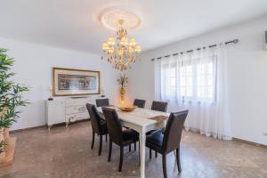 a dining room with a white table and black chairs at Villa Brisa do Mar by Algarve Holidays in Galé