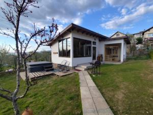 a small white house with a grass yard at "Goritsa" Guest House , Къща за Гости "Горица" in Ovchartsi