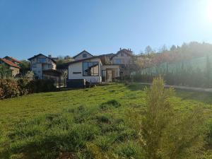 a house on the side of a grass field at "Goritsa" Guest House , Къща за Гости "Горица" in Ovchartsi