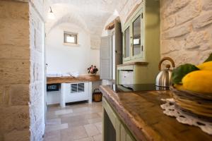 a kitchen with a counter with a sink and a counter top at Trullo Soave Suite - outdoor jacuzzi in Alberobello
