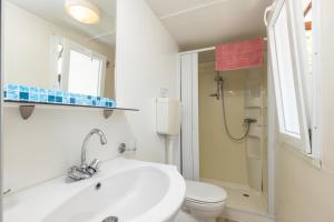 a white bathroom with a sink and a toilet at Campeggio la Mariposa in Alghero